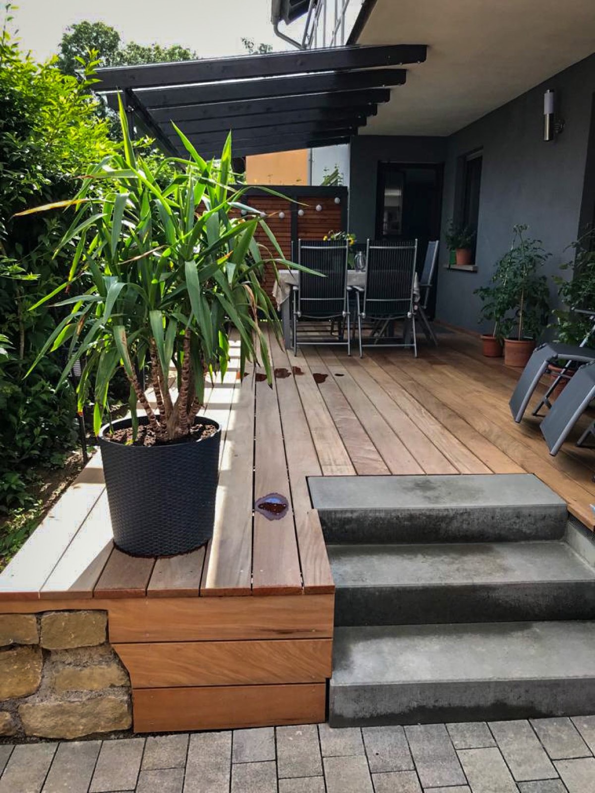 Terrasse umgestaltet mit Treppenstufen, teilweiser Überdachung, Sichtschutzwand und Garapa-Terrassenbelag